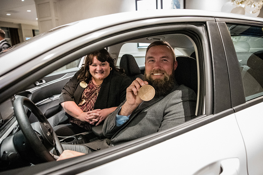 Ryan Degner is his new Kia, posing with Wiregrass President DeAnnia Clements