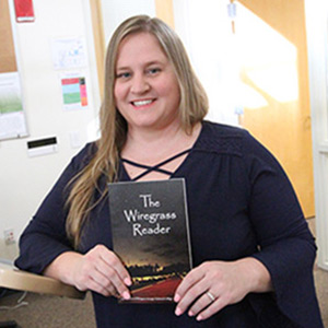 English instructor Cathy Leeman holding The Wiregrass Reader