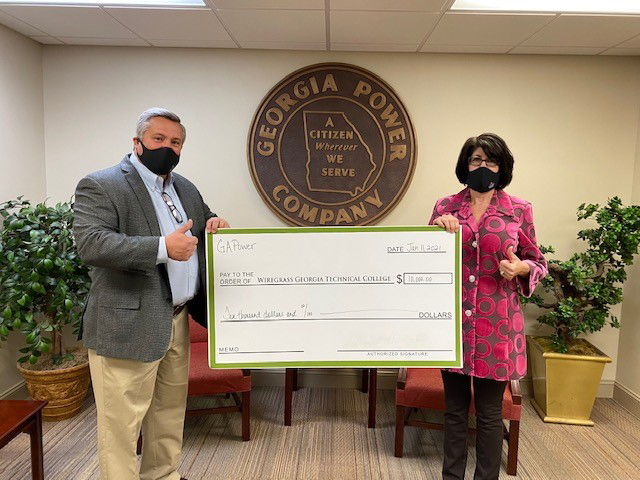 Georgia Power Region Director Joe Brownlee presenting Wiregrass President Dr. Tina K. Anderson with a $10,000 check