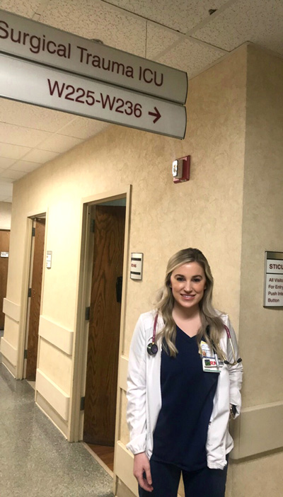 Sara Burdette standing in front of Surgical Trauma ICU sign