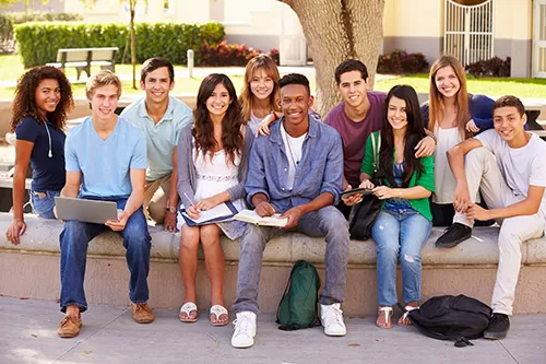 Group of high school students seated around a tree